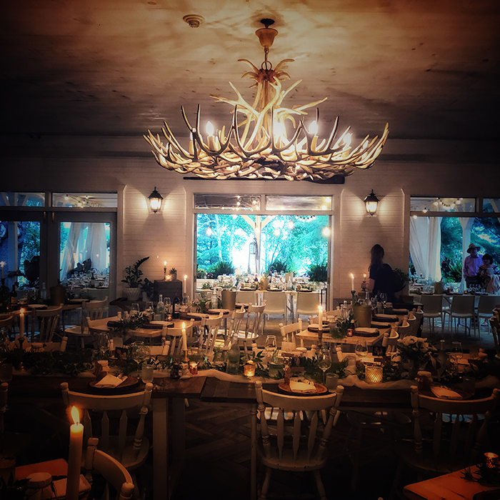 Candlelit dining room beneath an antler chandelier at The Northridge Inn and Resort